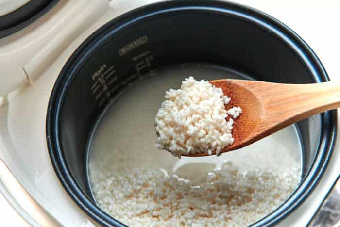 What are the advantages of cooking sticky rice in a sticky rice cooker